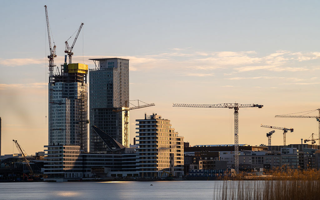 Stadsbilden i Fiskehamnens bostadsområde under uppbyggnad vid solnedgången.