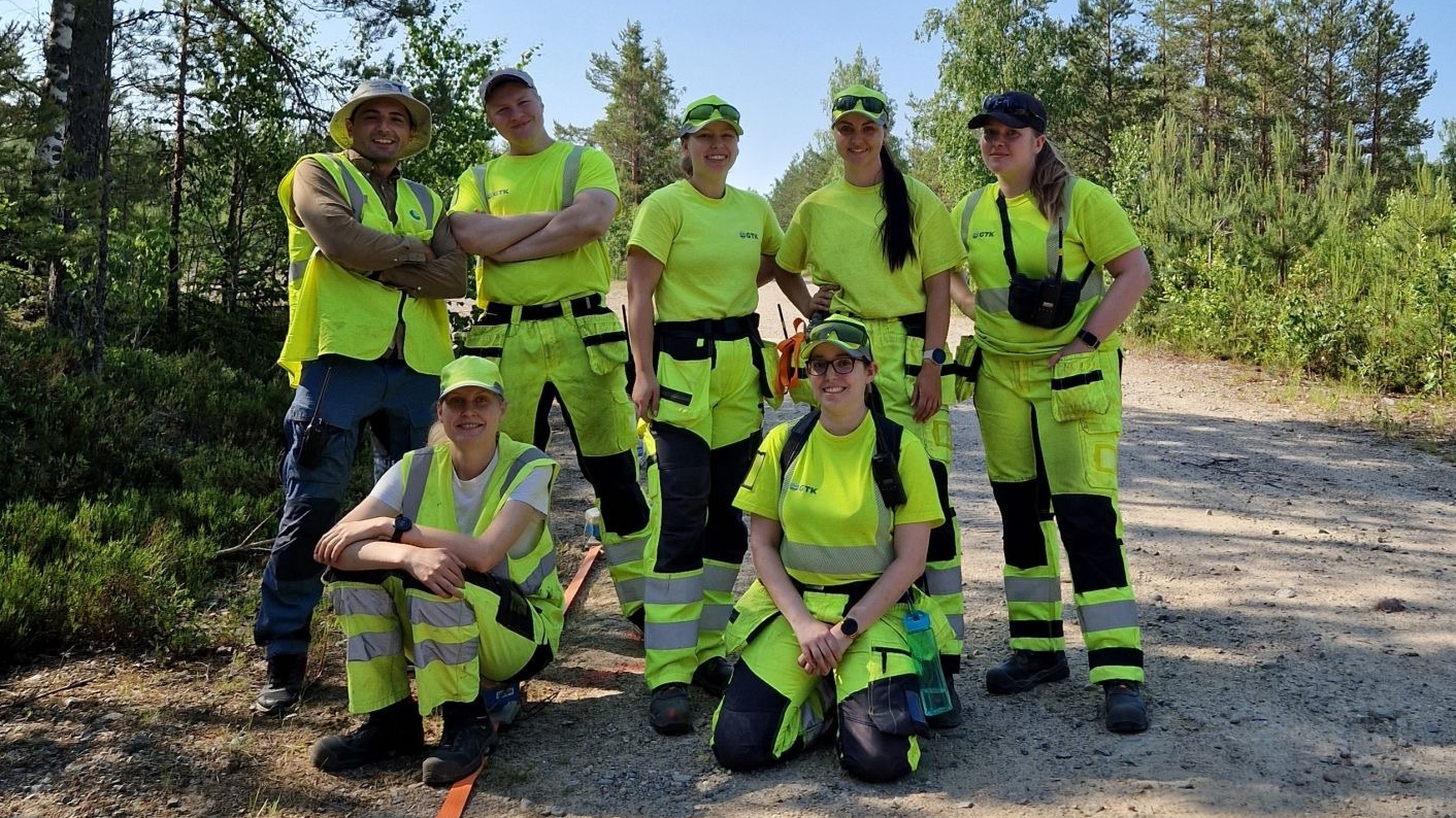 Joukko ihmisiä keltaisissa huomiovaatteissa poseeraamassa kameralle