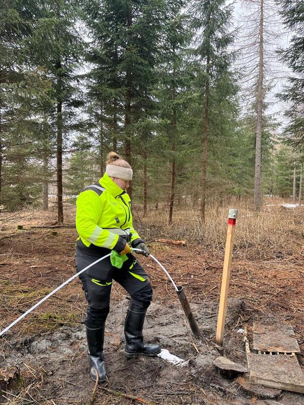 Henkilö keltaisissa huomiovaatteissa tekemässä letkuprofiilinäytteenottoa.